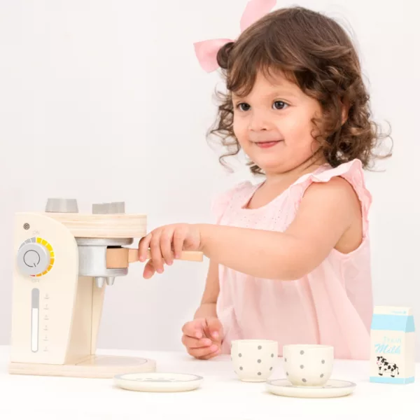 Момиче сервира кафе с дървена кафемашина New Classic Toys за ролеви игри 3+