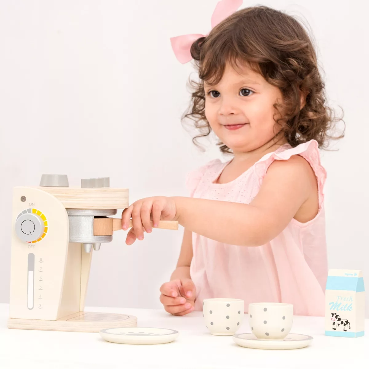 Момиче сервира кафе с дървена кафемашина New Classic Toys за ролеви игри 3+