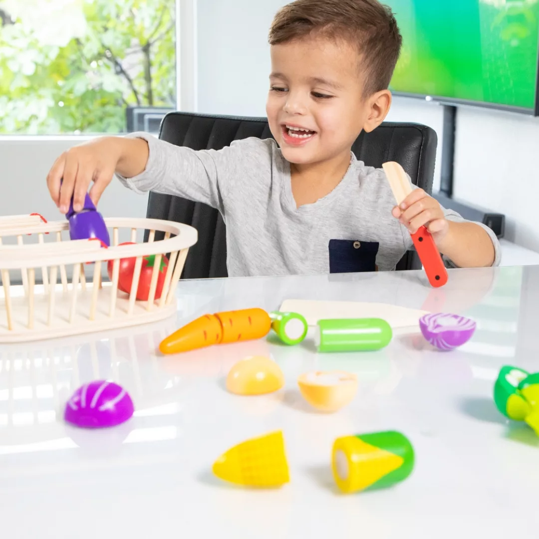 Дете играе с кошница със зеленчуци за рязане New Classic Toys дървена играчка