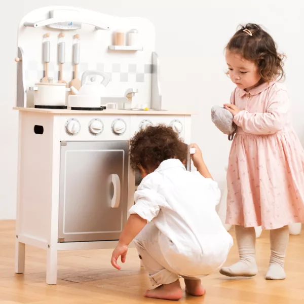 Деца играят с дървена кухня Лукс в бяло и сиво – New Classic Toys