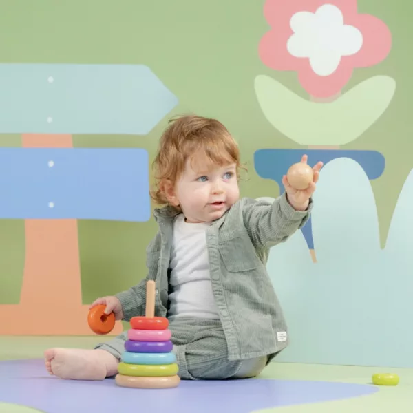 Бебе играе с дървени рингове Дъга New Classic Toys в пастелни цветове