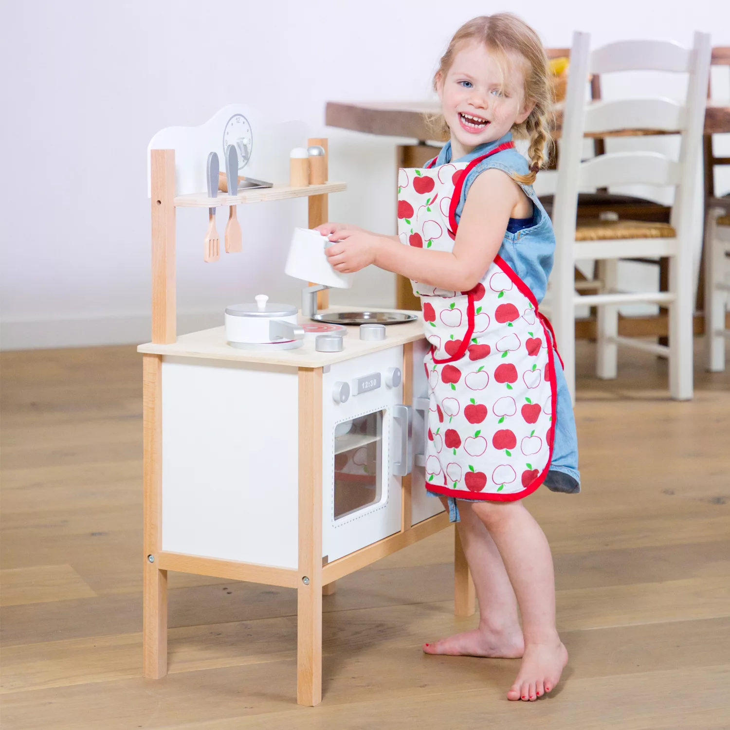 Момиче играе с дървена кухня Класик в бяло – New Classic Toys