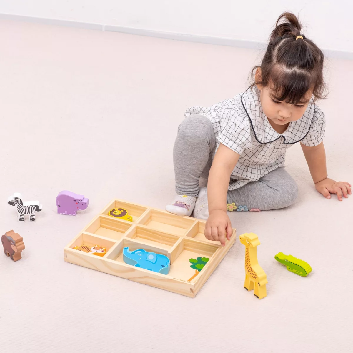 Момиче играе с дървени животни от джунглата New Classic Toys