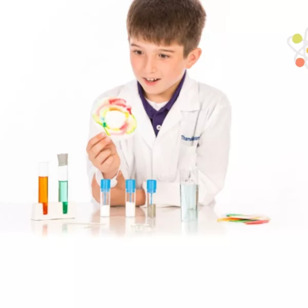 Дете с лабораторно облекло експериментира с химичен комплект Thames and Kosmos