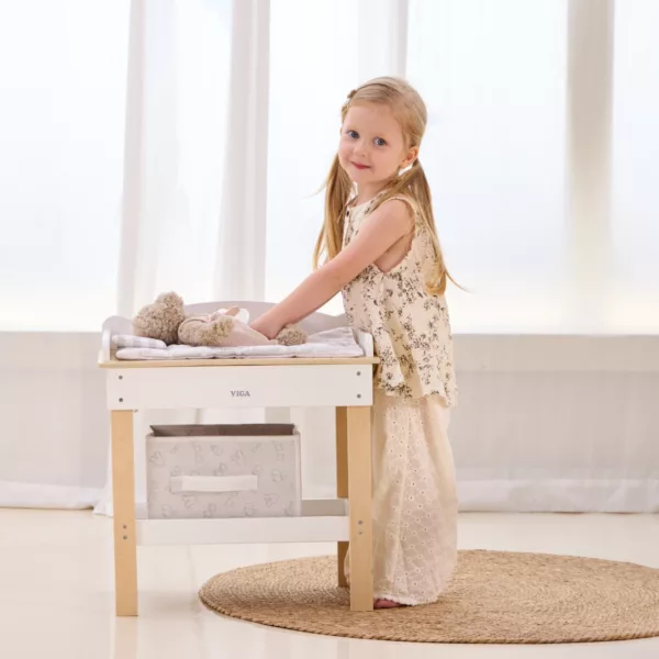 Дете играе с дървена маса за повиване на кукли VIGA Toys