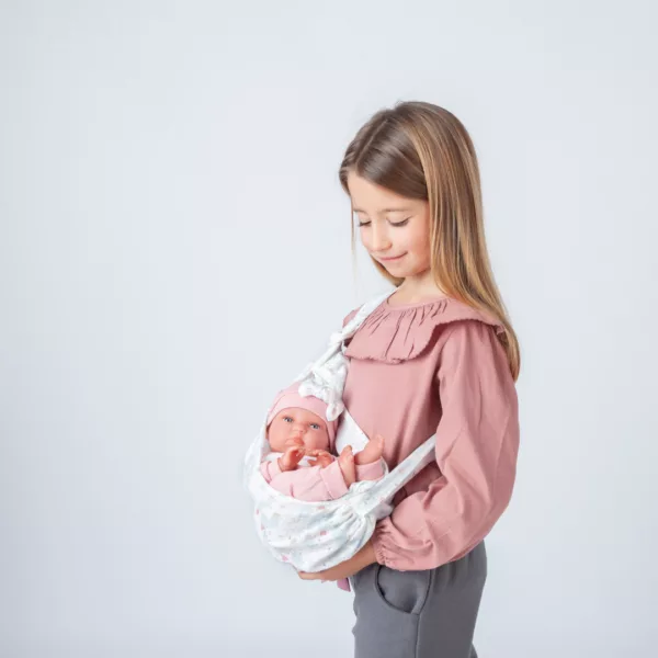 Момиче прегръща кукла бебе Тея в чанта за носене емоционално развитие деца