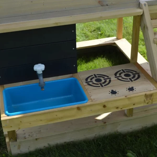 Детска площадка Wendi Toys с кухня - кухненският модул който е монтиран в дървеният игрален комплекс върху зелена трева в градината