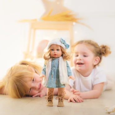 Две деца със стилна кукла Marina & Pau, облечена в зимен тоалет с шапка и шал, от Bellamiestore