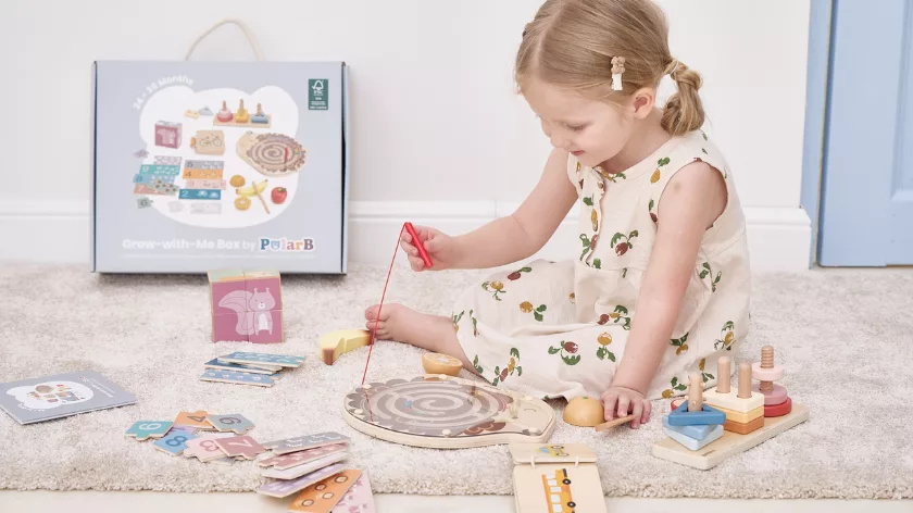 Момиченце играе с дървена образователна играчка лабиринт PolarB