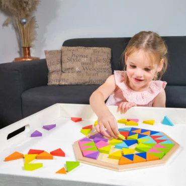 Момиче играе с дървена мозайка от геометрични форми от New Classic Toys, предлагана в Bellamiestore