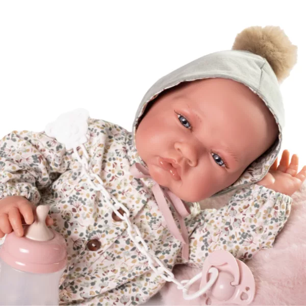 Близък план усмихнато кукла бебе с шапка и флорални дрешки