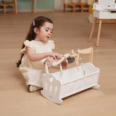 Момиче играе с дървено креватче за кукли Viga toys - образователна играчка от Bellamiestore за ролеви игри