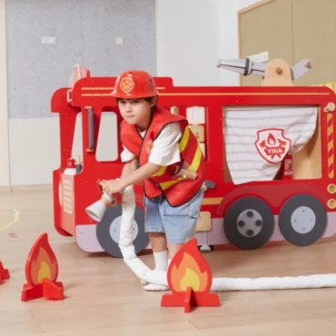 Дете в пожарникарски костюм с дървена пожарна Viga toys - образователна играчка от Bellamiestore за ролеви игри