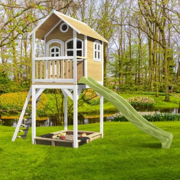 Къщичка за игра Romy AXI 2 в 1 с пързалка и пясъчник в озеленен двор.