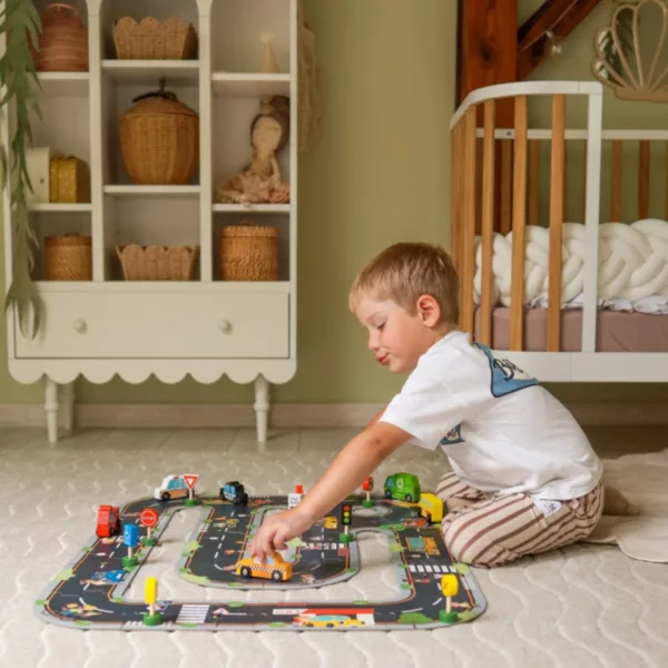 Момче реди пъзел градски път с колички в детска стая, подходящ за над 3 години