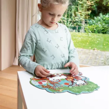 Момиче реди картонен пъзел със животни, цветна образователна игра за деца, развиваща моториката