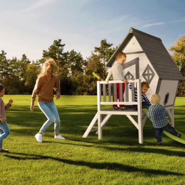 Дървена детска къща с веранда и стълба в бяло и сиво, играчки за навън, двор