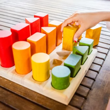 Дървена дъска с цветни цилиндри и призми за развитие на моторика и логика, Монтесори стил