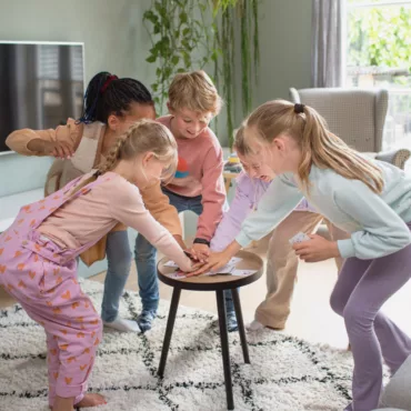 Деца играят настолна състезателна игра на масичка, развиваща бързина и реакция