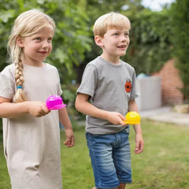 Деца играят класическа игра яйца с лъжица на открито, развиваща баланс и забавление