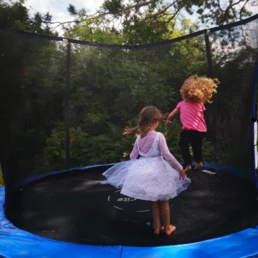 Детски батут с предпазна мрежа, подходящ за игри на открито и физическа активност, за деца над 3 години.
