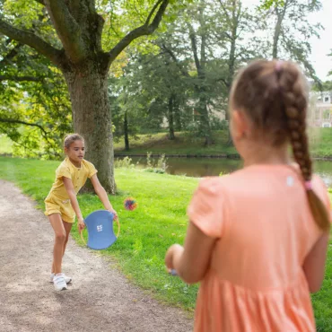 Детски комплект за хвърляне и хващане на топка, подходящ за забавление навън и спортни игри.