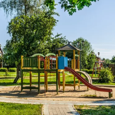 Цветна детска площадка с пързалка, катерушки и сенник за забавления на открито