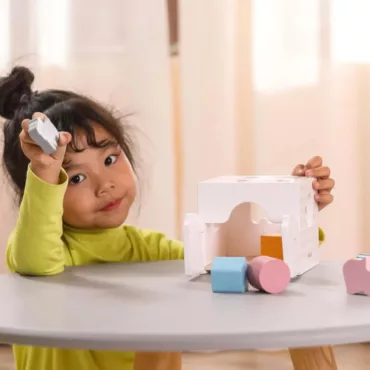 Дете играе с дървен сортер за форми, бебешка образователна играчка, пастелни цветове, подходяща за 1+ година