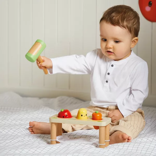 Бебе играе с дървена игра с чукче и зеленчуци Janod
