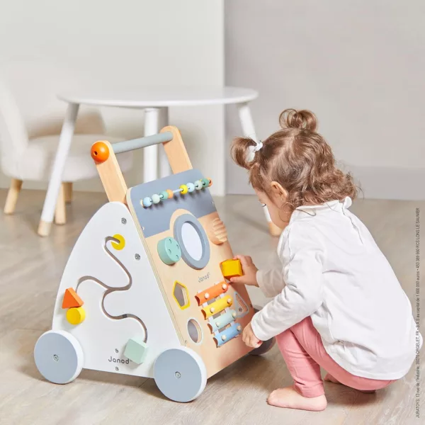 Дете играе с дървена проходилка с активности Sweet Cocoon от Janod