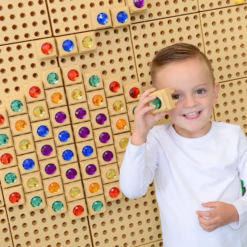 Усмихнато дете държи Masterkidz цветен диамант за STEM табло