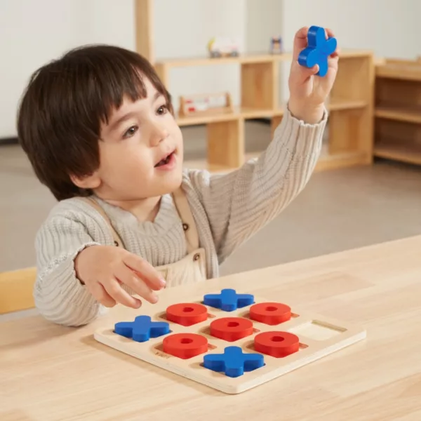Момче вдига синя фигура от морски шах – Дървена игра от VIGA Toys