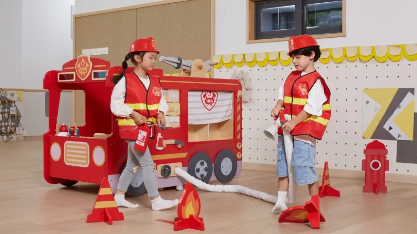 Ролева игра пожарна станция от Viga Toys с деца в костюми пожарникари