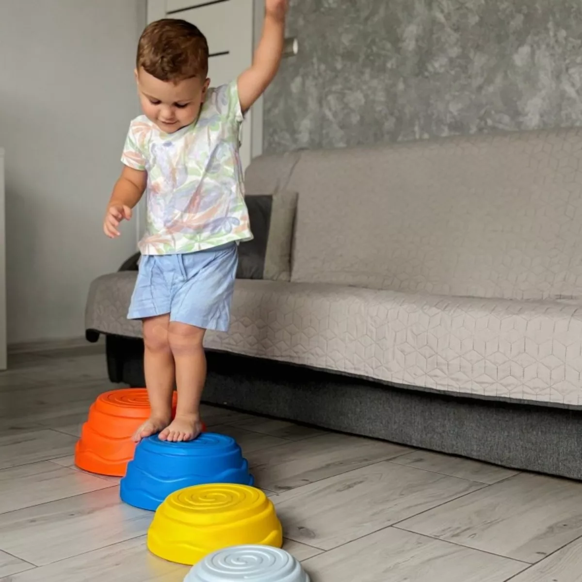 Дете играе със сензорни камъни за баланс Jolly у дома за развитие на координацията