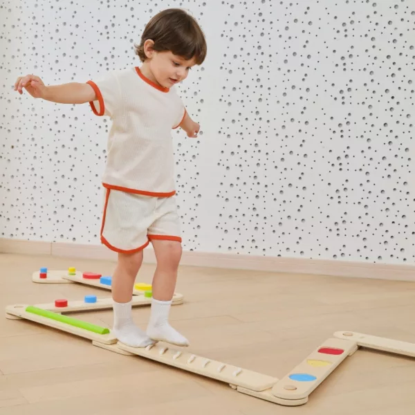 Дете тренира баланс върху дървена сензорна пътека VIGA Toys с различни модули