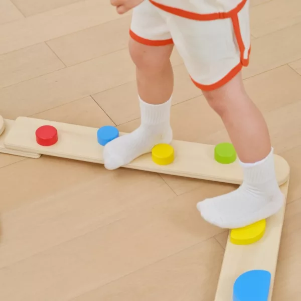 Крачета на дете върху дървен модул с цветни кръгове от сензорната пътека VIGA Toys