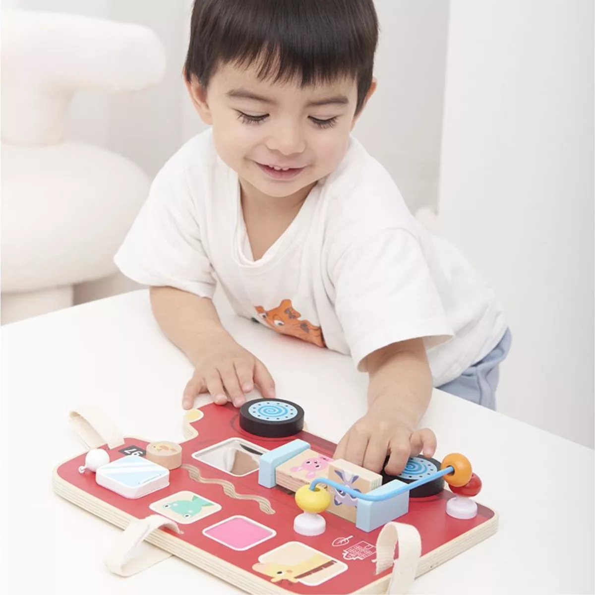 Дете играе с дървен бизиборд автобус Lelin и развива фина моторика