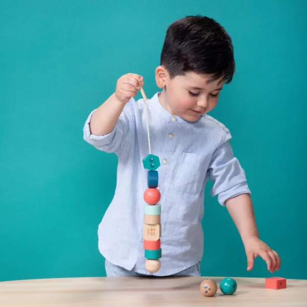 Дете нанизва дървени мъниста върху връв – Монтесори игра от BS Toys