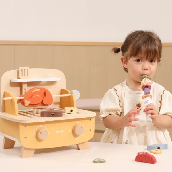 Дете играе с дървен барбекю комплект PolarB, нанизвайки зеленчуци на шиш