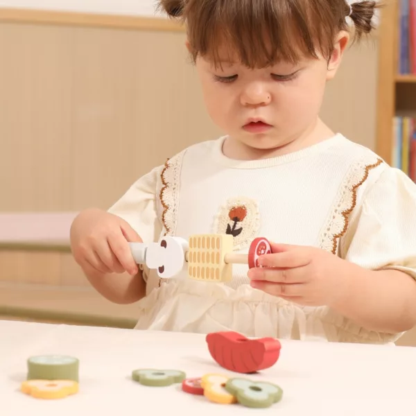 Дете нанизва дървени храни на шиш от барбекю комплекта PolarB