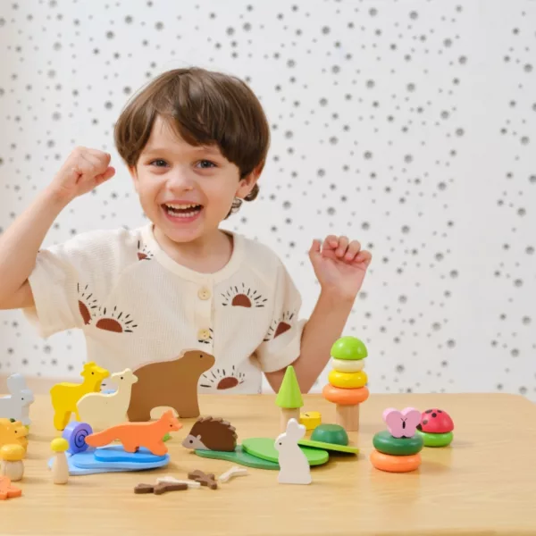 Весело дете играе с дървен конструктор с животни Горски свят Viga