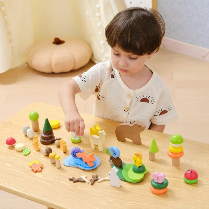 Дете подрежда дървените животни и елементи от конструктора Горски свят