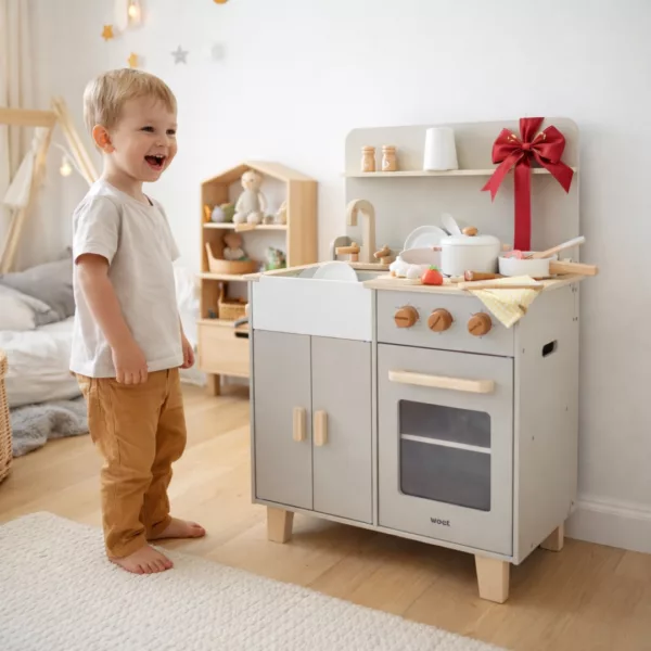 Детска дървена кухня в бежово сканди в детска стая с играещо дете
