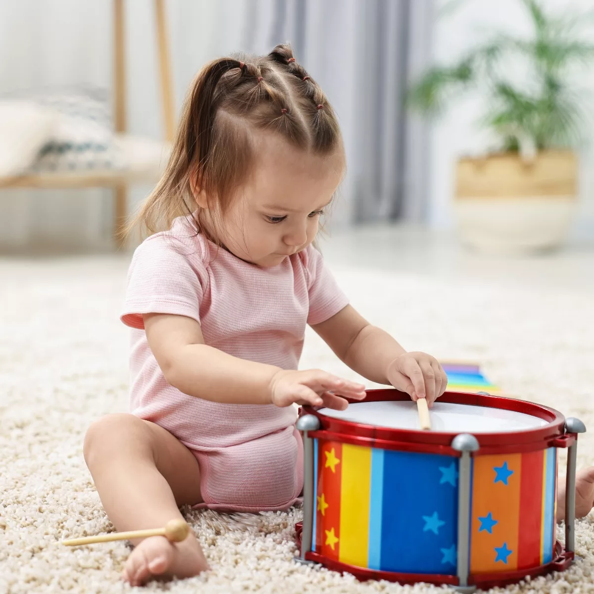 Музикални и занимателни бебешки играчки – малко дете свири на цветен барабан