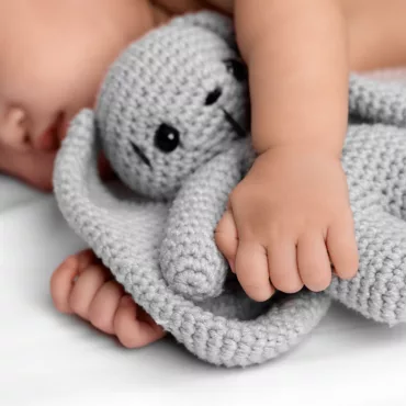 Меки и плюшени играчки за бебета – бебе държи плетено слонче