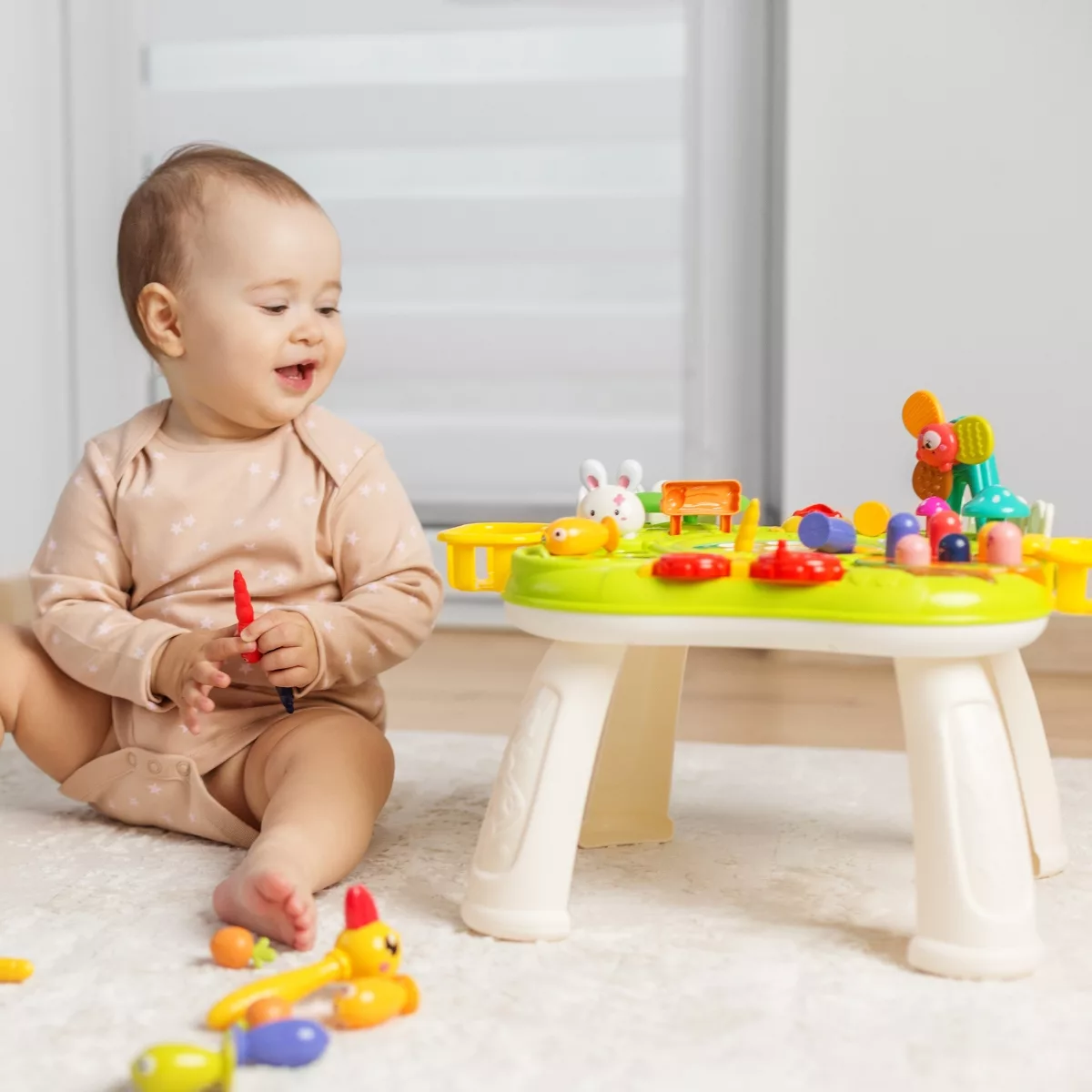 Бебе играе със занимателна маса с активности и цветни елементи