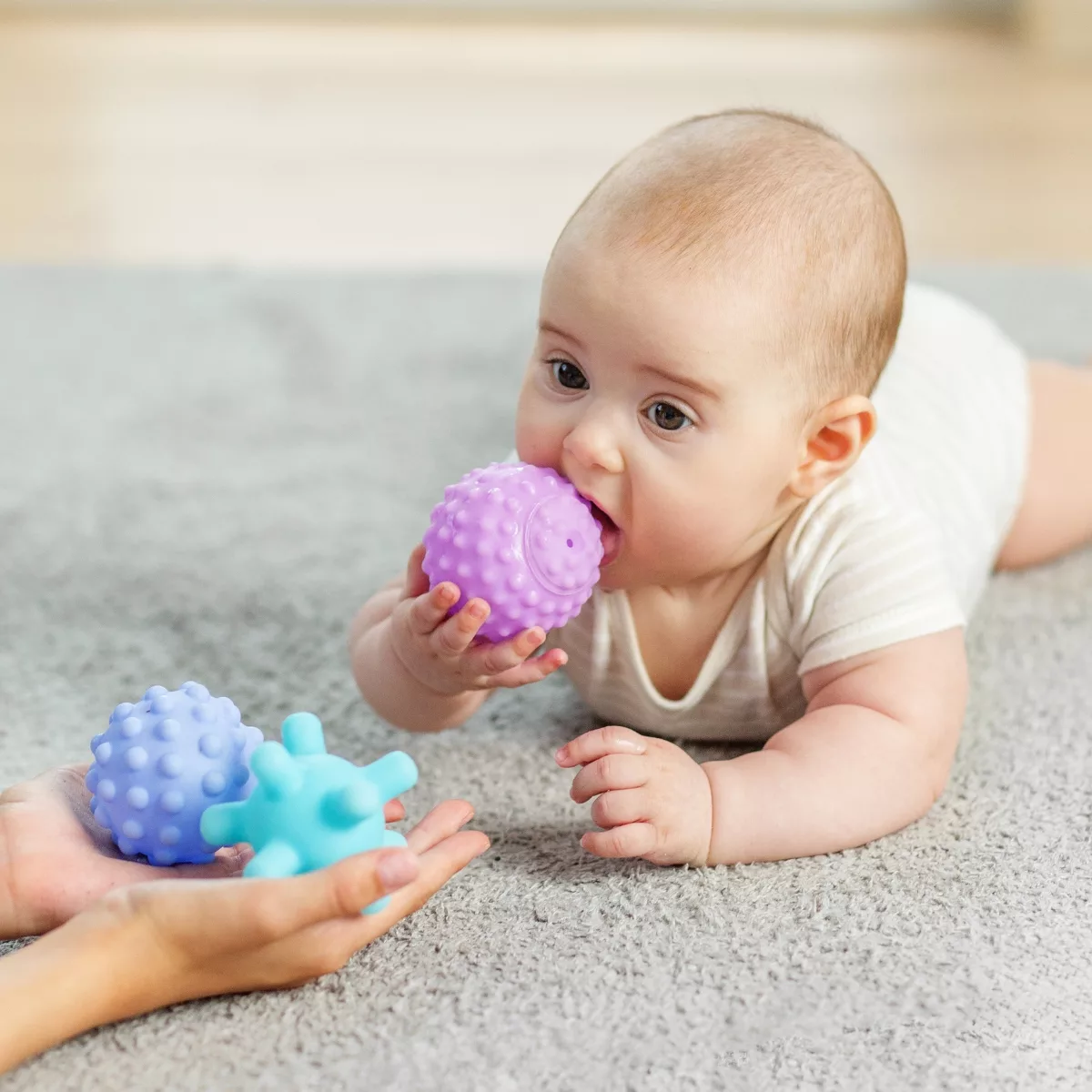 Дете играе със сензорни меки играчки в пясъчна зона за игра