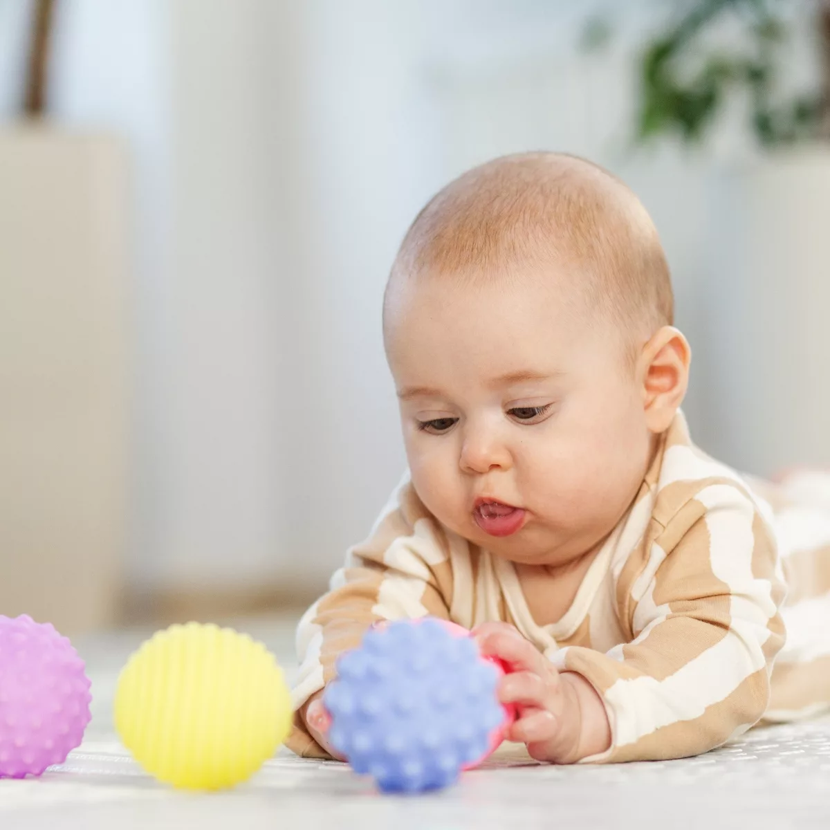 Бебе играе с малка дървена количка мека и сензорна играчка