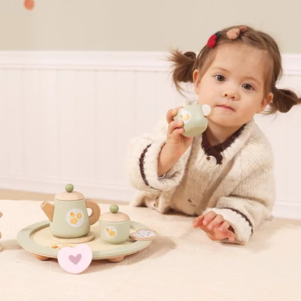 Дете държи дървена чаша от сервиз за чай PolarB играчка за чаено парти