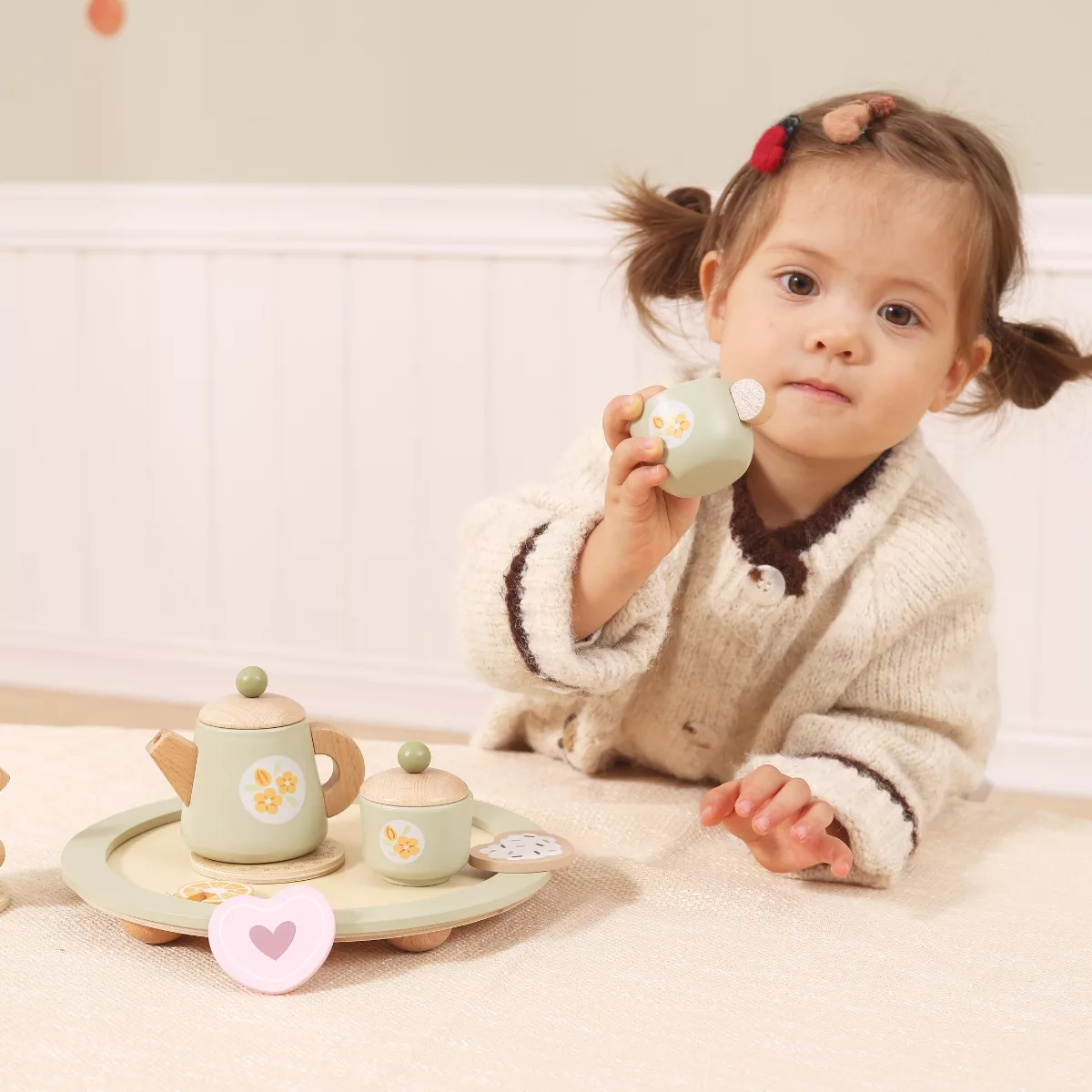 Дете държи дървена чаша от сервиз за чай PolarB играчка за чаено парти
